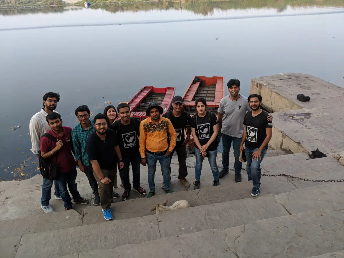 Earth5R volunteer team at a Yamuna ghat with boats after a river cleanup in Delhi