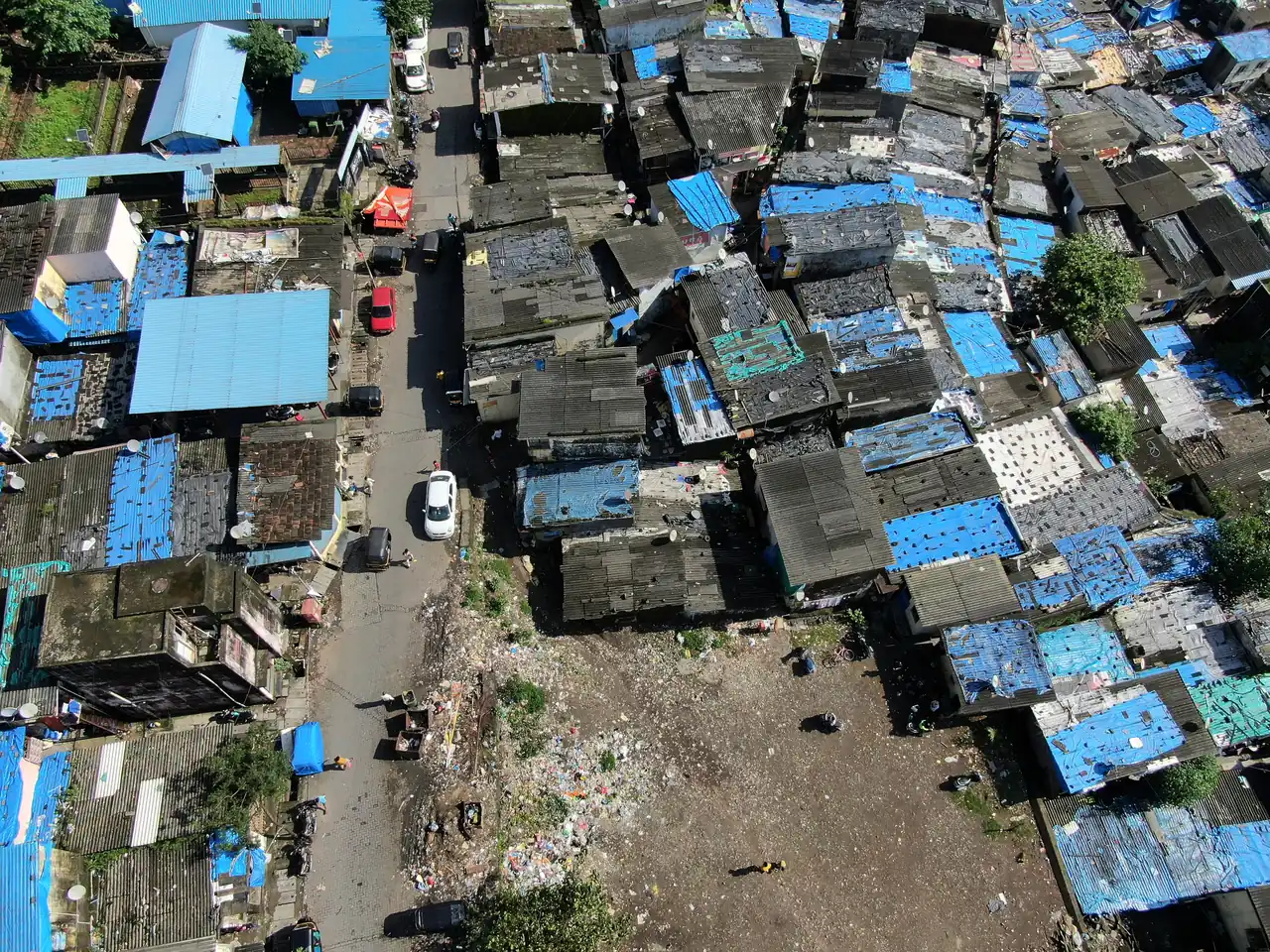 High school geography internship field work. Aerial view of dense rooftops covered with blue tarpaulins in an informal settlement