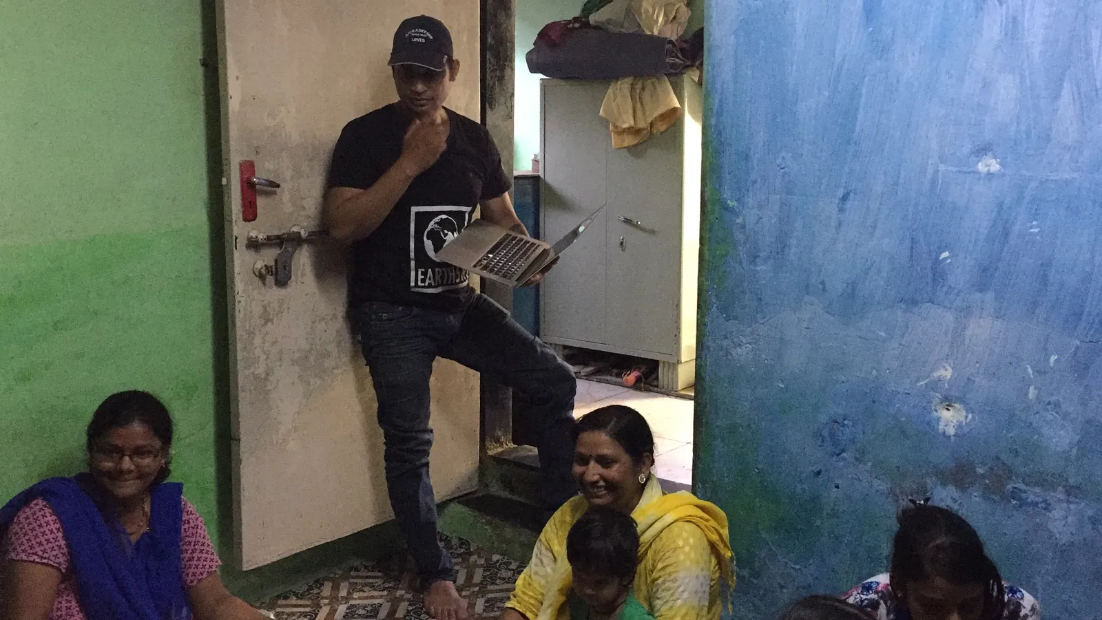 Marketing internship field work. Earth5R volunteer showing an awareness poster to residents at their doorway