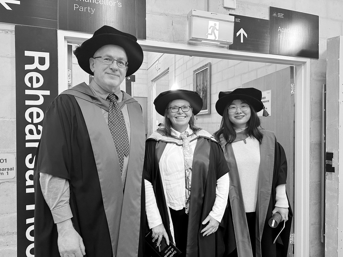 Professor David Stern in academic dress with Professor Sharon Bessell and Xueting Jiang, outside the Rehearsal Room at an ANU graduation ceremony