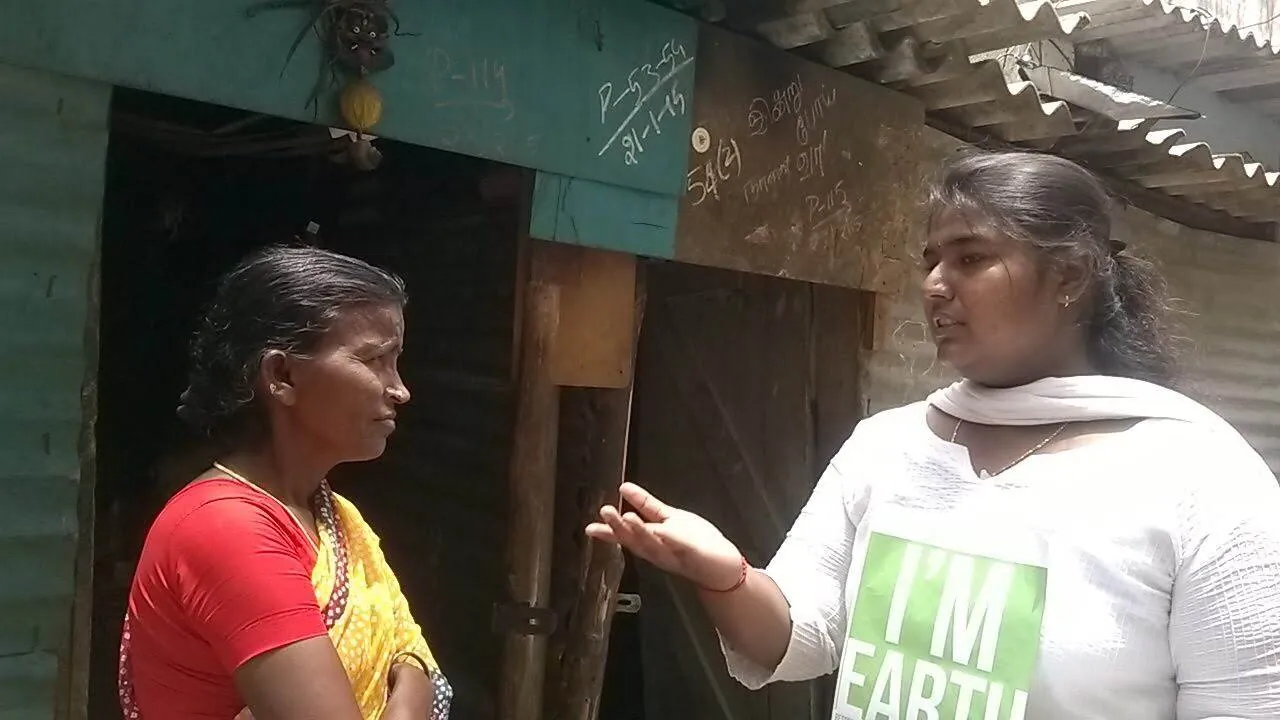Earth5R volunteer talking to a resident at her doorway during a door-to-door household survey
