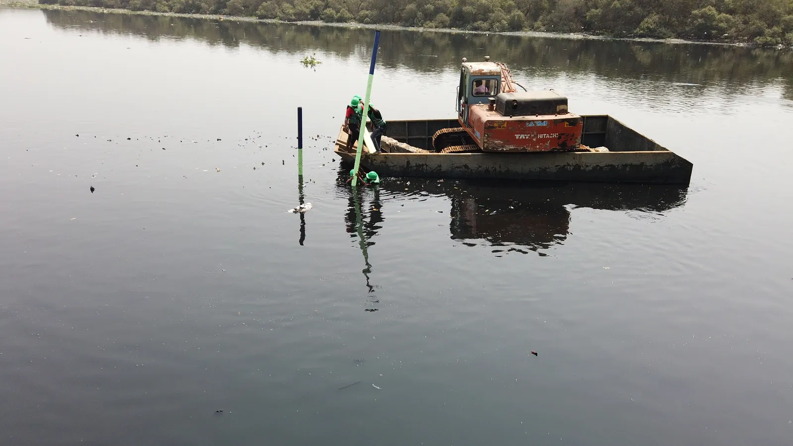 High school mechanical engineering internship field work. Floating trash collection device on a still river
