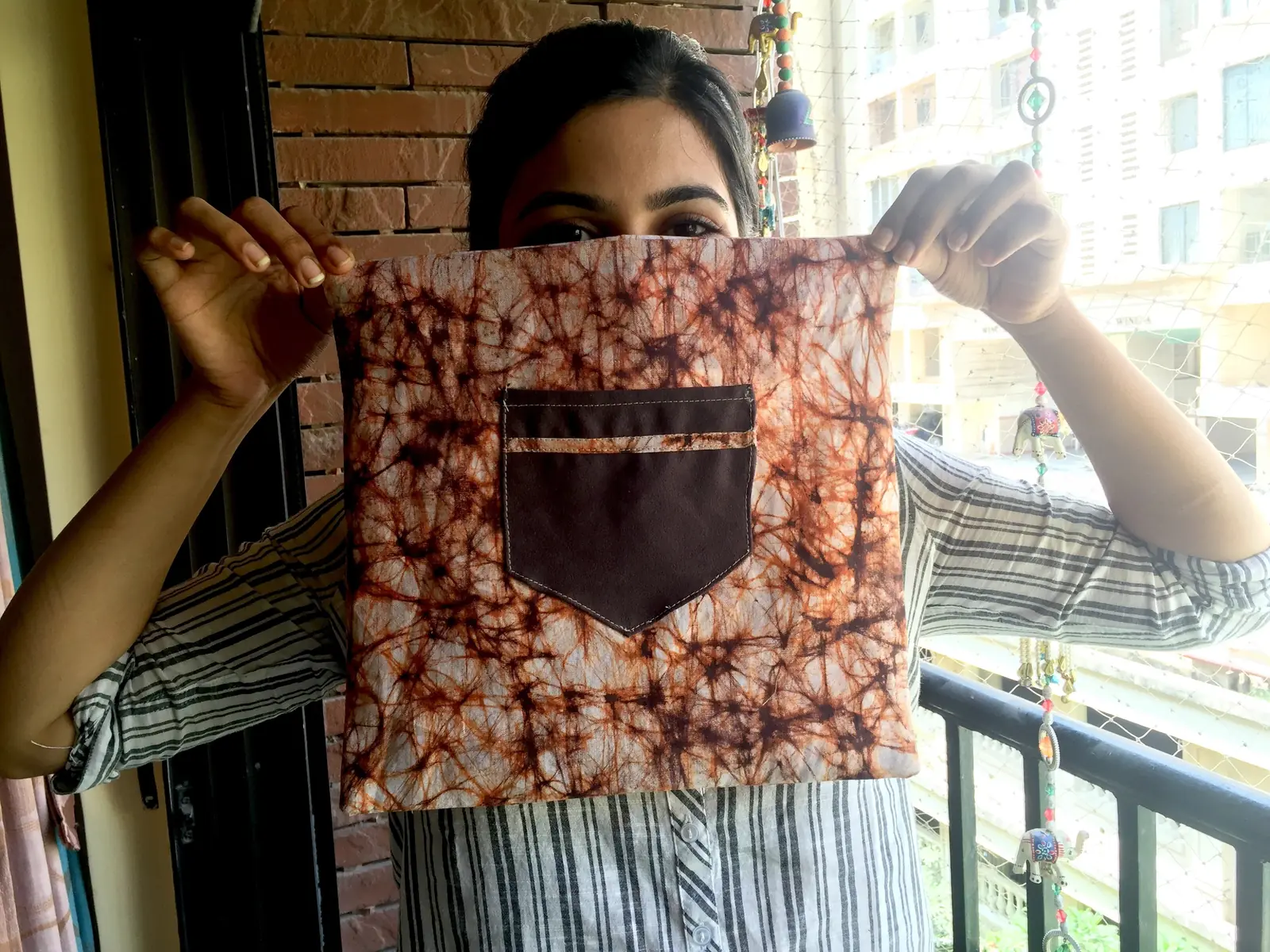 High school entrepreneurship internship field work. Woman holding up a handmade cloth bag made in an Earth5R livelihood training