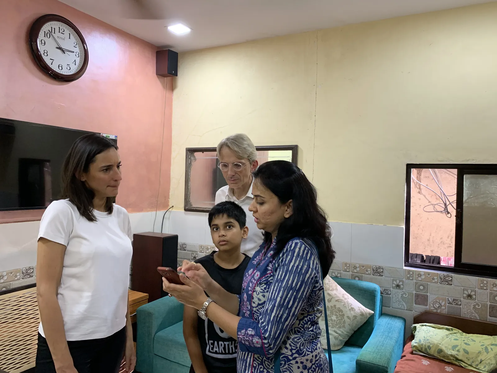 Earth5R volunteers talking with a woman inside her home during a household survey