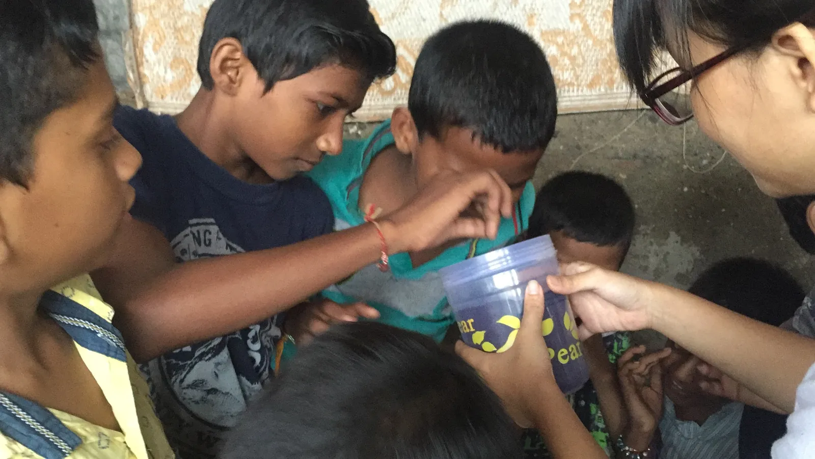 High school chemistry internship field work. Boys looking closely at an object during a hands-on environment science activity in Powai, Mumbai