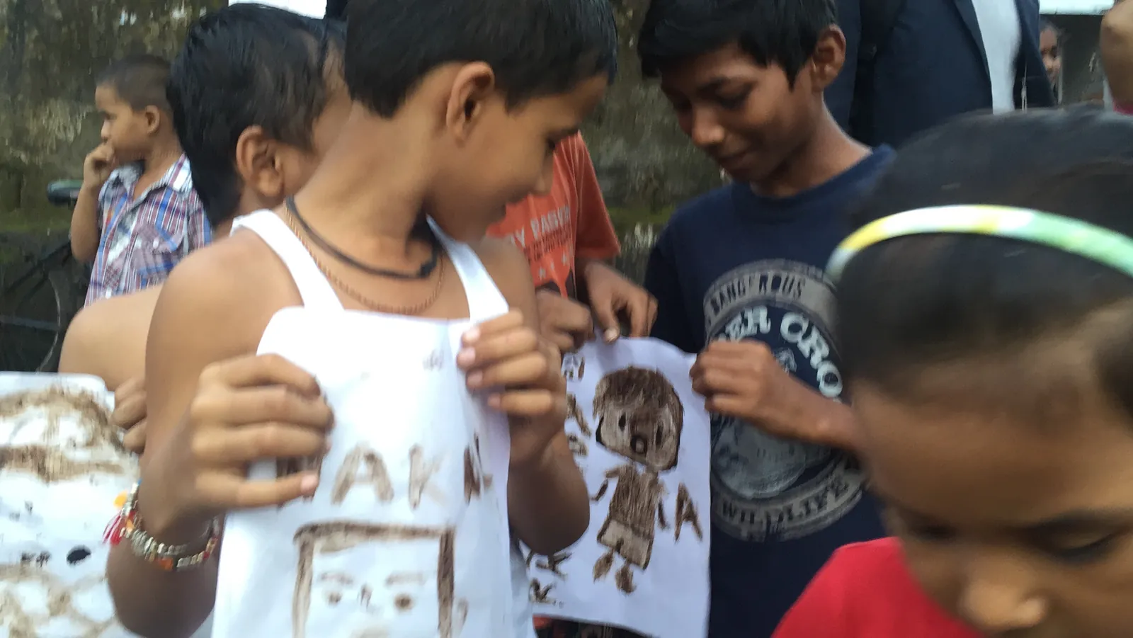 High school fashion design internship field work. Children showing T-shirts they decorated in an upcycling and art session in Powai, Mumbai