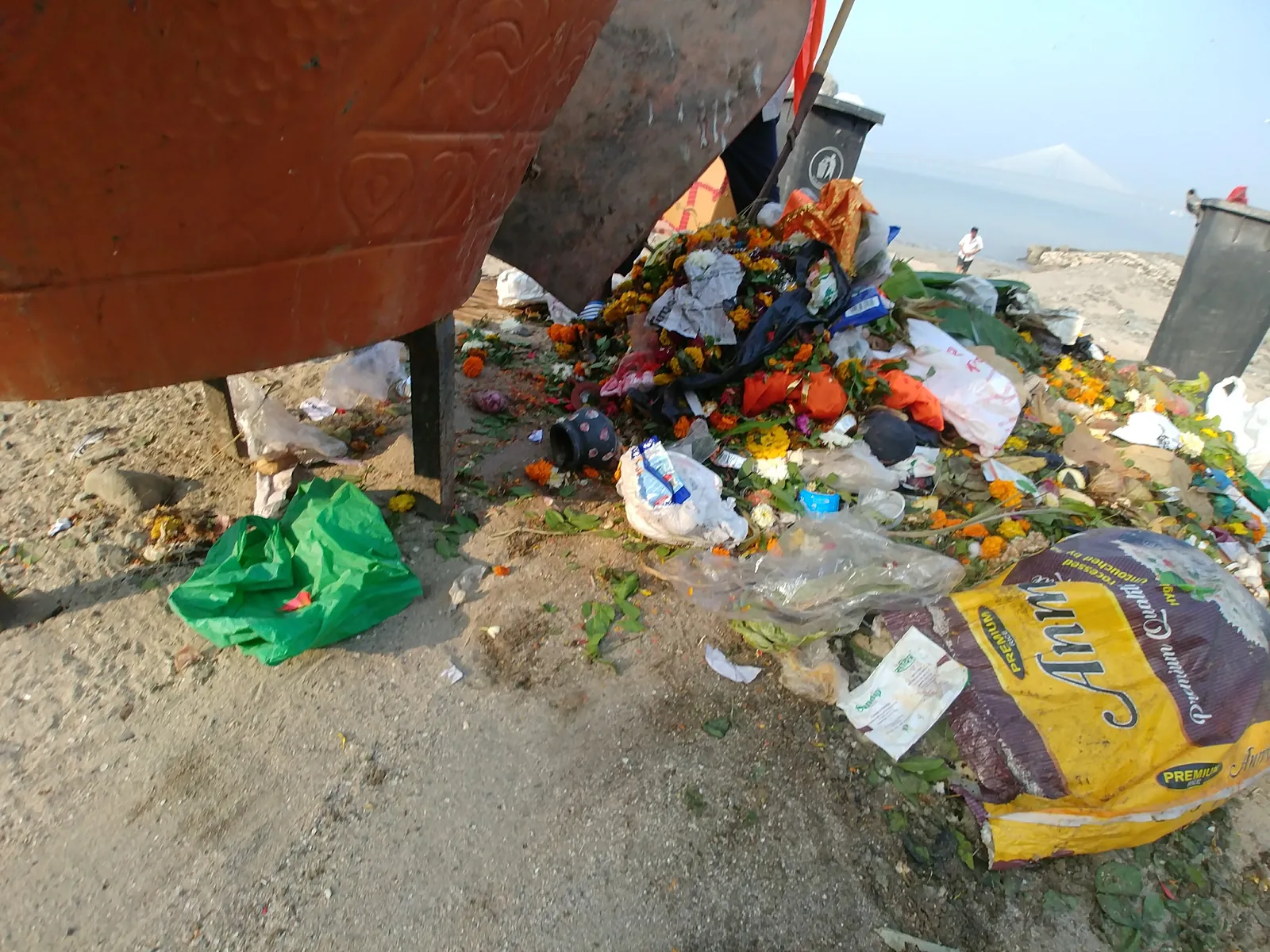 Overflowing garbage bin and spilled waste at a street corner in Mumbai