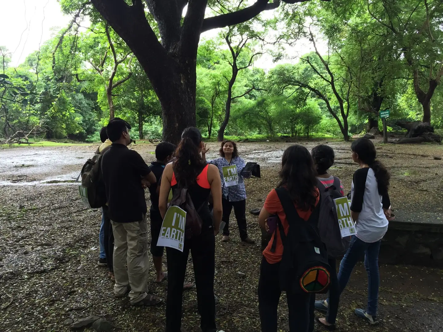 Biology internship field work. Students and Earth5R volunteers walking under large trees on a forest nature trail in Sanjay Gandhi National Park, Borivali, Mumbai
