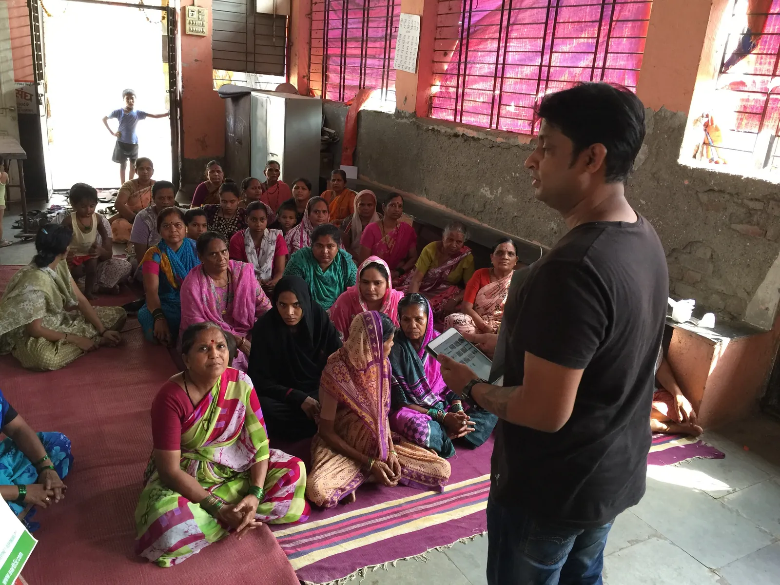 Earth5R trainer addressing about 20 women seated on the floor of a community hall in Powai, Mumbai