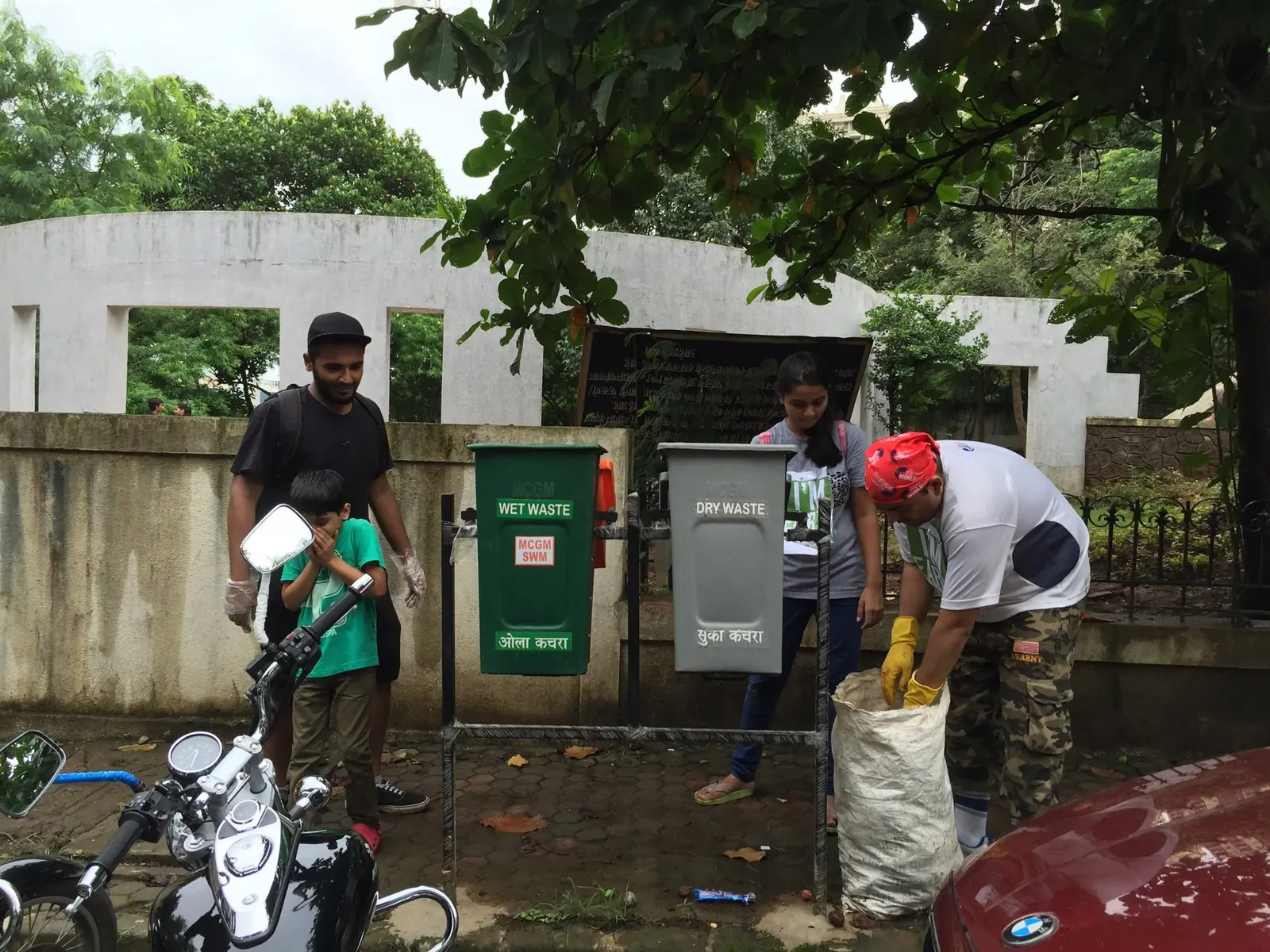 Earth5R volunteers beside a green and grey waste bin station on a roadside in Mulund West, Mumbai