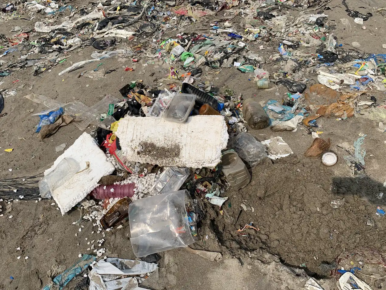 Plastic and broken debris dumped on open ground