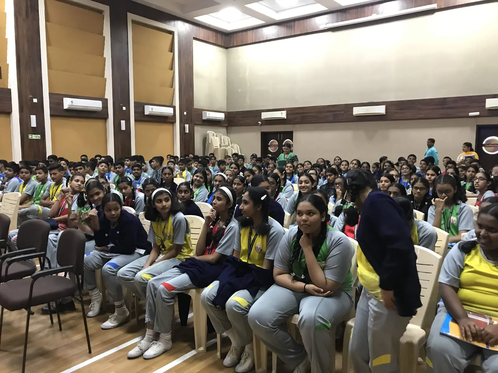 High school marketing internship field work. School auditorium packed with uniformed students at an Earth5R awareness session
