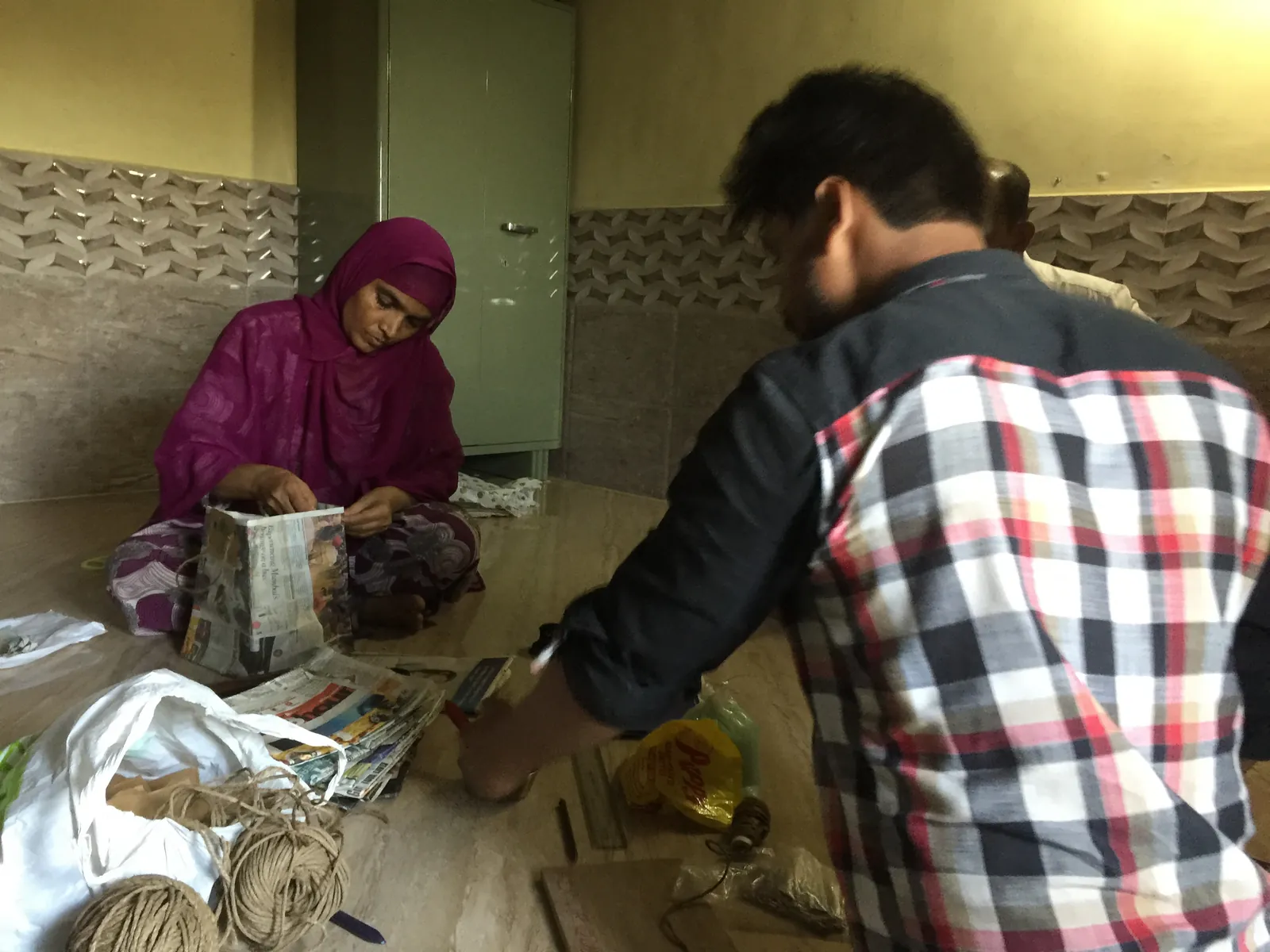 Earth5R volunteer and a woman sorting household waste materials on the floor during segregation training