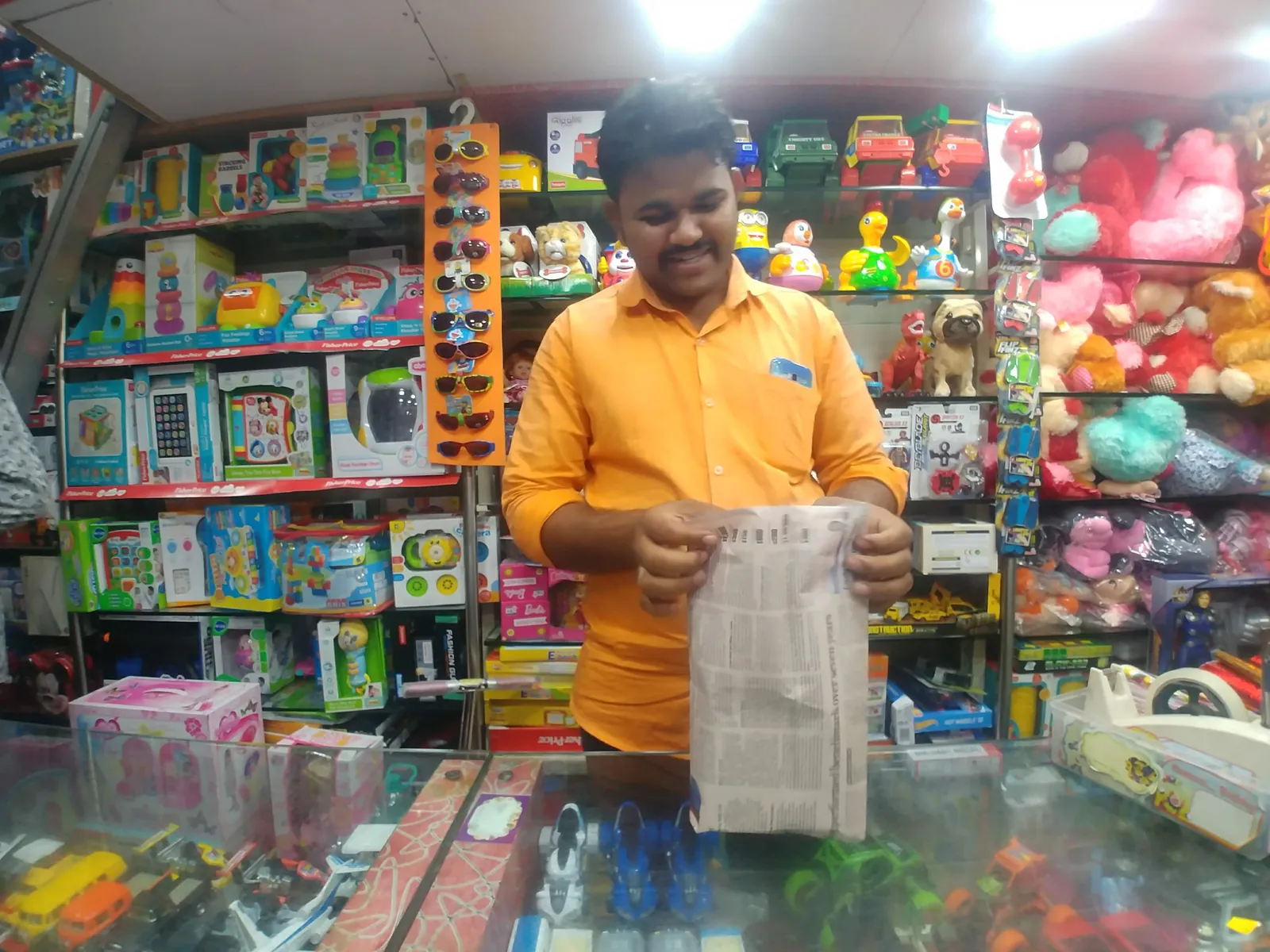 High school law internship field work. Shopkeeper in a toy shop holding up a reusable bag offered in place of plastic