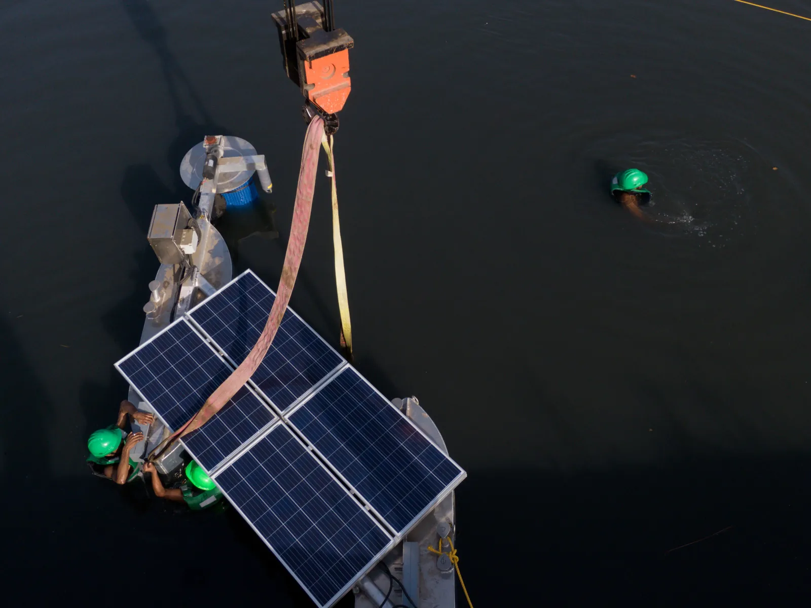 Water resources internship field work. Overhead view of a solar-powered floating device with sensors on dark river water