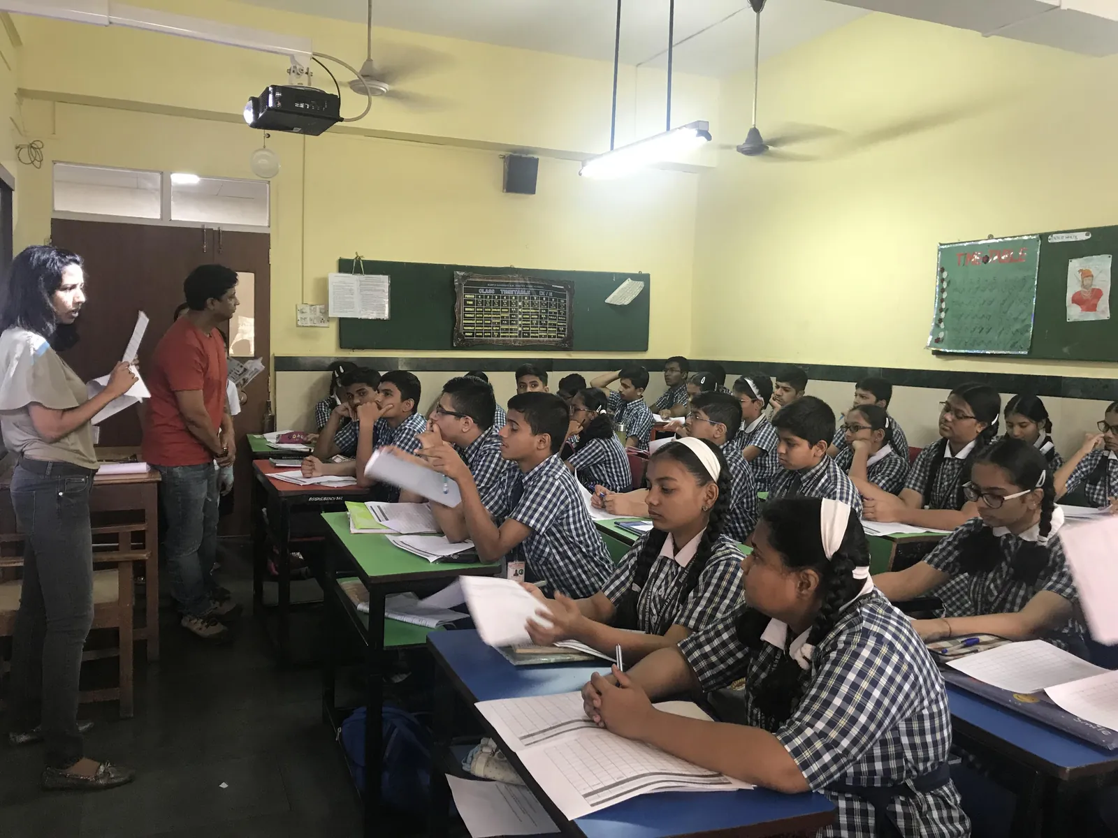 High school coding internship field work. Students in uniform writing at their desks during an Earth5R classroom session
