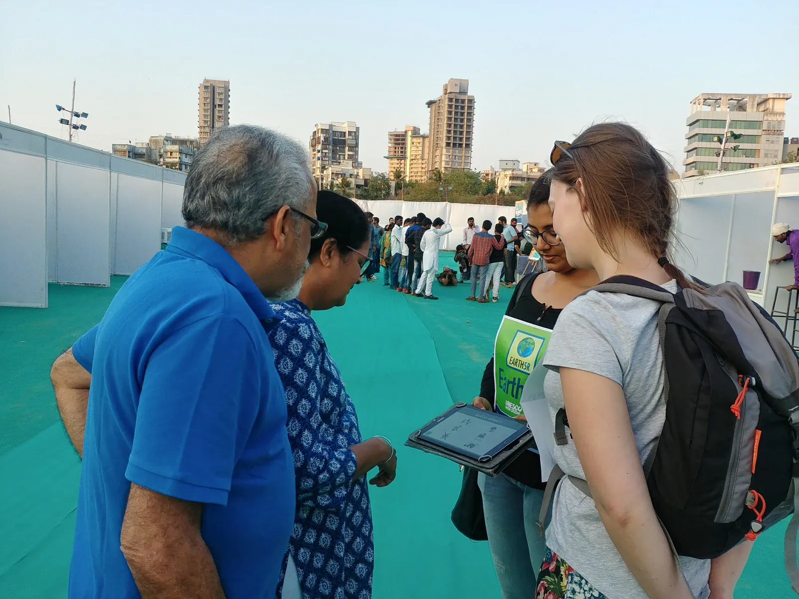 International visitors talking with a local resident on a waterfront during a community visit