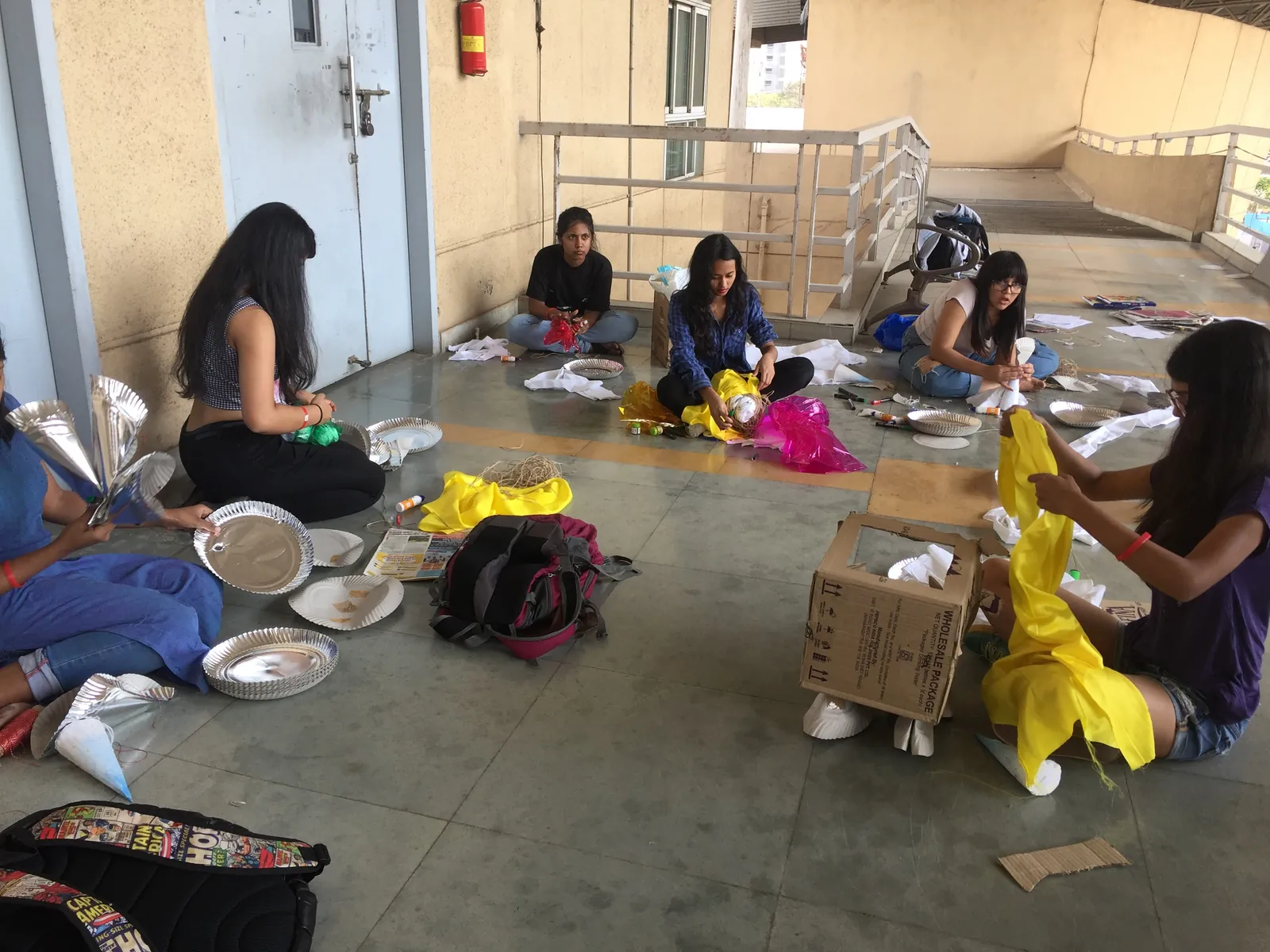 High school fashion design internship field work. Women sorting textiles and craft materials on the floor for upcycled products